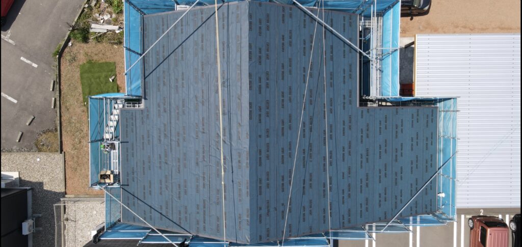 下葺き材を屋根全体に張った施工途中の空撮写真